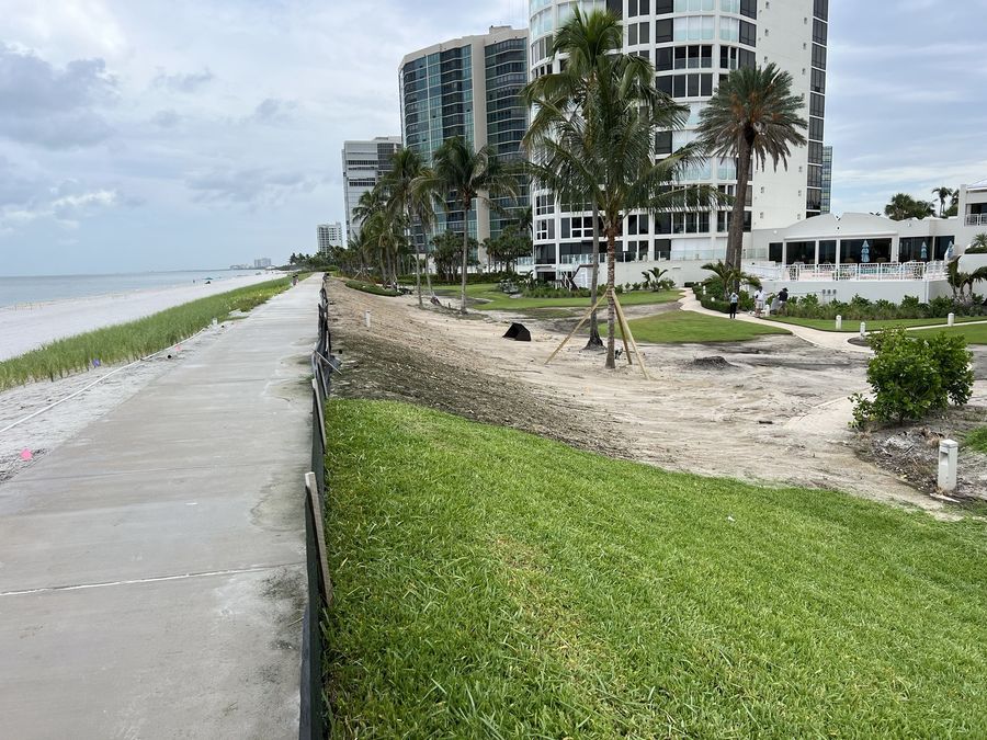 Fresh sod laid along a beach walkway with condo towers behind