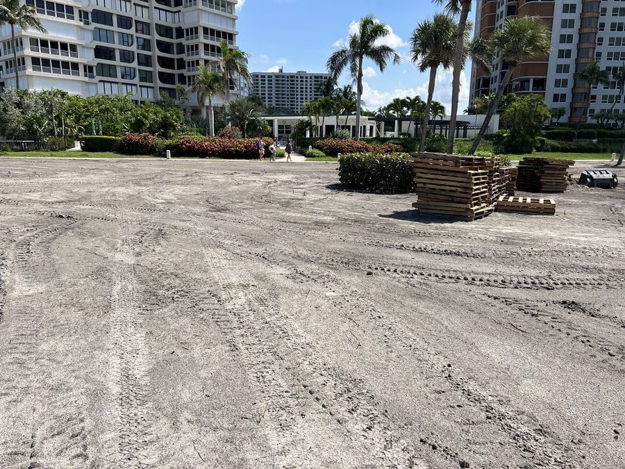 Graded sand site with empty sod pallets stacked