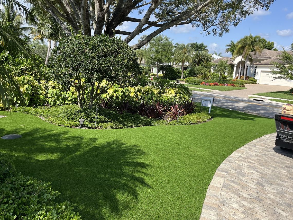 Artificial turf front lawn curving around a planting bed