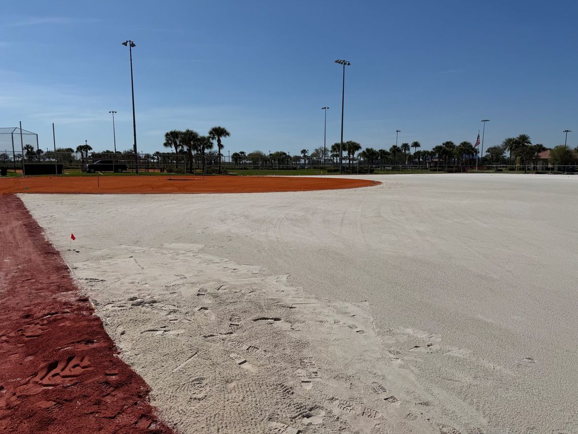 Outfield graded to a white sand base beside the clay infield
