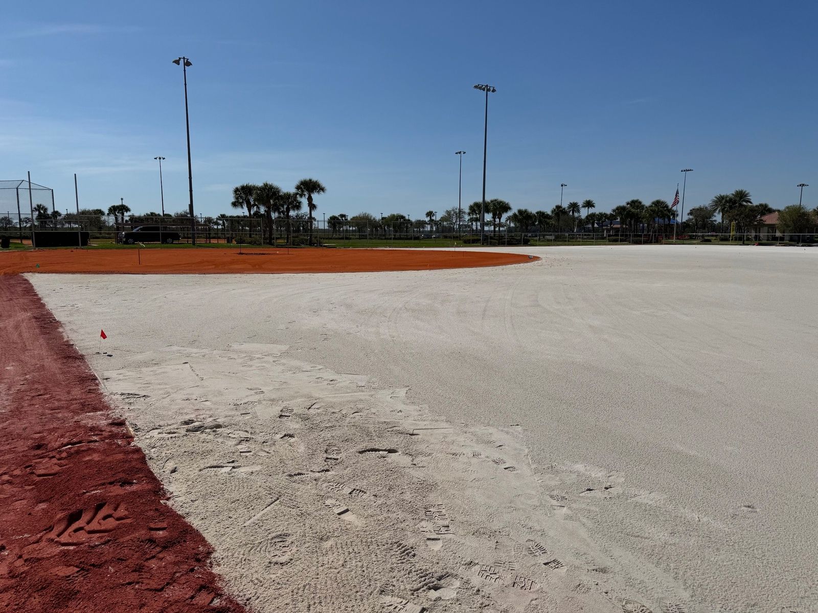 Outfield graded to a white sand base beside the clay infield