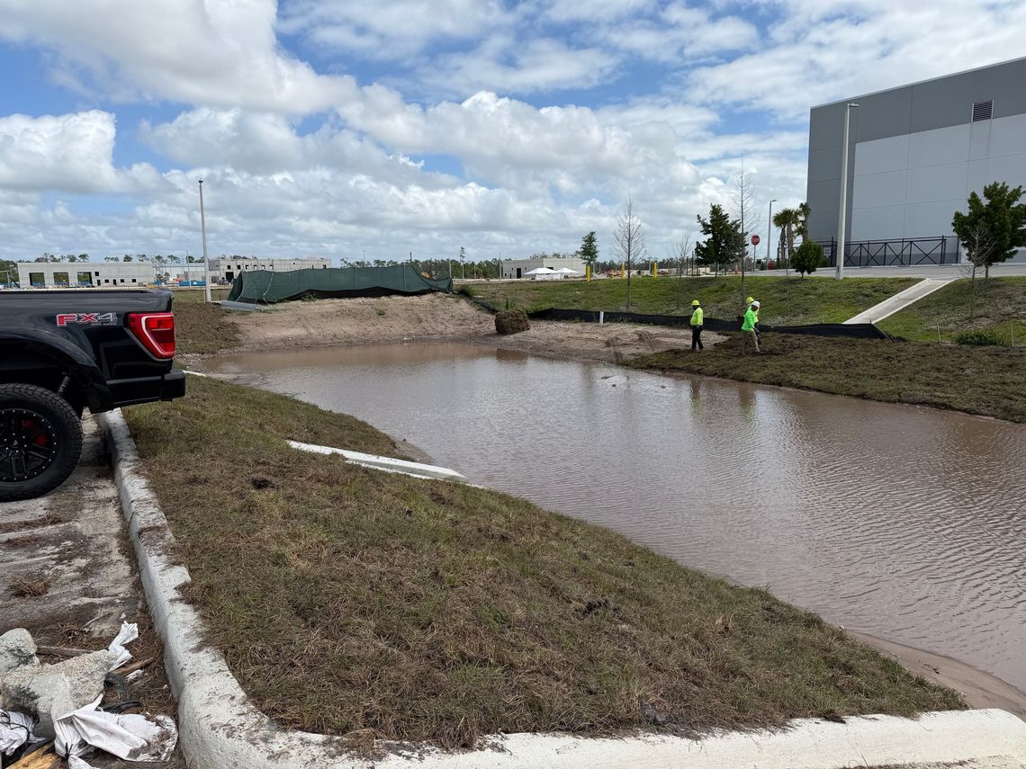Crew sodding retention pond banks at a commercial site