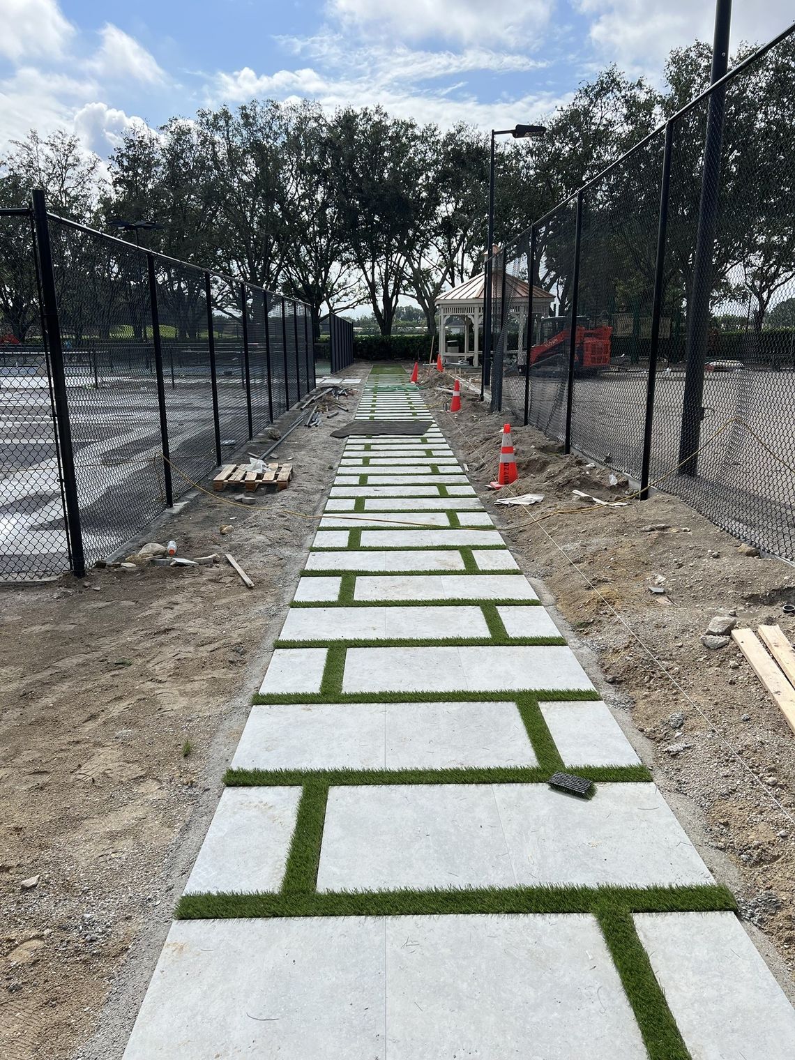 Artificial turf inlaid between slabs along a court walkway